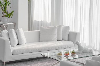 Otelde beyaz kanepesi olan bir oturma odası. Beyaz konsept oturma odası iç mekanı. Lüks villadaki modern kanepe..