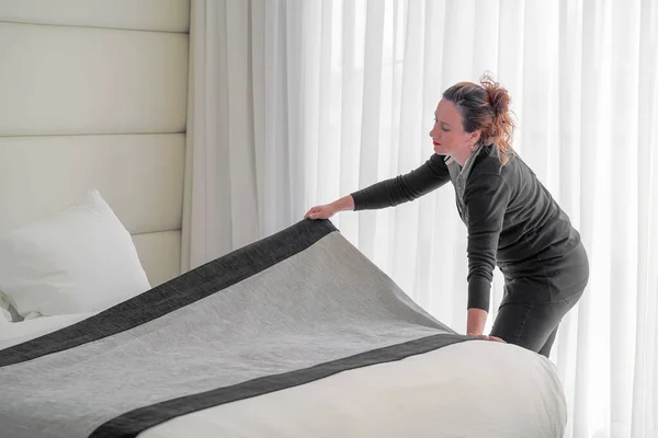 女服务员的手在酒店房间里整理床铺 管家铺床 — 图库照片