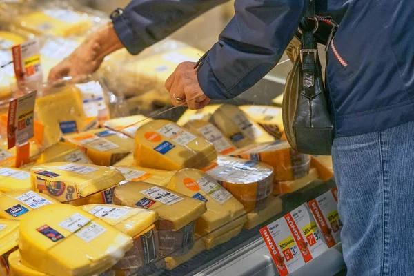 衣衫褴褛的老妇人手在超市里捡奶酪 老妇人在超市里选择奶酪 女性养恤金领取者在杂货店里选择奶酪 September 2018 鹿特丹 — 图库照片