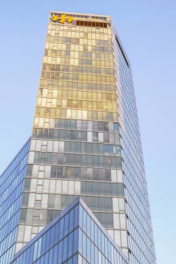 Mavi gökyüzüne karşı modern gökdelen ofis binaları. Yüksek bina. Modern şehir mimarisi. Camdan ve betondan yapılmış evler. Aşağıdan gökdelenlerin görüntüsü.