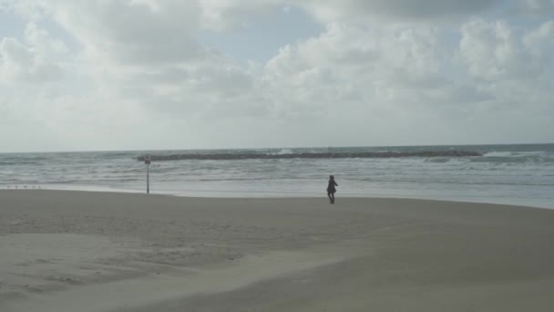 Зимой Женщина Гуляет Одна Пляжу — стоковое видео