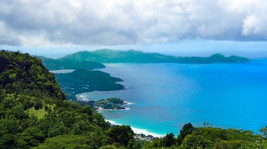 Seyşeller sahil beyaz plajları ve bulutlu gökyüzü altında yemyeşil yeşil ormanları ile Panorama görünümünü   