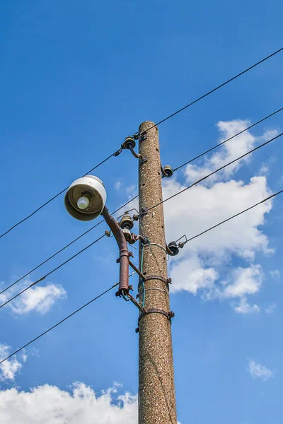 旧的混凝土电报杆与复古路灯在蓝色的天空前面 从下面查看 — 图库照片