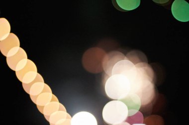 Beyaz, sarı, yeşil farklı ışıklar ve sol tarafında bir bokeh zincir gibi renklerle bir bokeh arka plan. İdeal doku veya desen.