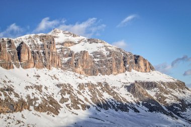 İtalyan Dolomites Dağları Fassa Vadisi Gruppo Sella Ronda kışın açık mavi gökyüzü ve bazı bulutlarla. Güney Tirol 'deki Sass Bece dağ istasyonundan görüntü