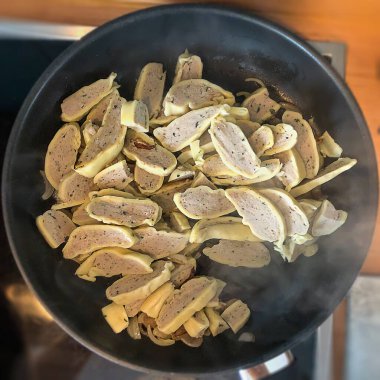 Lezzetli Swabian spesiyali Maultaschen soğanlı bir tavada dilimlenmiş.