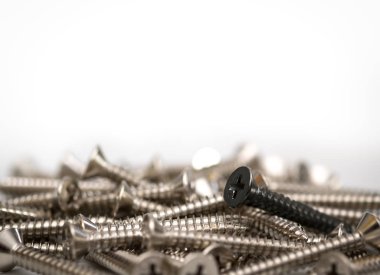 Siyah bir vida kopya alanı, fikir kavramı ile beyaz arka plan üzerinde gümüş vida yığını.