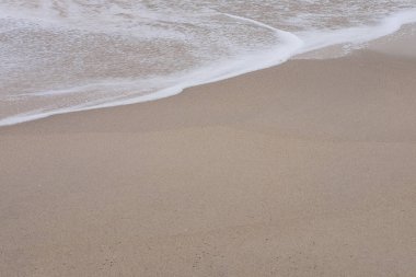 Deniz ve kum plajındaki kopya alanı ile beyaz temiz köpük dalga.