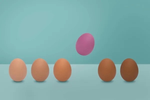 Που φέρουν ροζ αυγό και διαφορετικές αποχρώσεις χρωμάτων των αυγών σε μπλε πίσω — Φωτογραφία Αρχείου