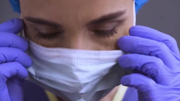 El cirujano caucásico se quita la mascarilla y sonríe. Fin de la operación, cuarentena, epidemia. Alegre sonrisa feliz abierta después del tratamiento útil coronavirus. Clip ProRes 422, grabado en 4K UHD . — Vídeo de stock