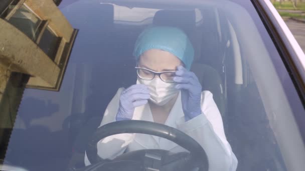 Complexity of the work of a virologist or doctor during the virus pandemic. Sad female nurse outside the hospital cries in a car. Lost power and disappointed doctor. ProRes 422 clip, shot in 4K UHD. — Stock Video
