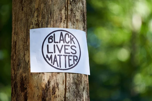 Kiev, Oekraïne - 31 juli 2020: Zwarte Levens Materie inscriptie in cirkel op boom. Stop racisme concept. Foto van Black Lives Matter protestbord. Actie tegen discriminatie. — Stockfoto