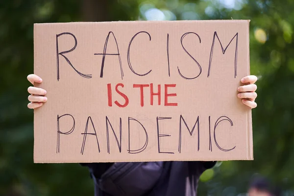 Kiev, Ucrania - 31 de julio de 2020: El racismo es el cartel pandémico que la persona sostiene. Detener el concepto de racismo. La vida de los negros importa signo de protesta. Acción contra la discriminación por color de piel. —  Fotos de Stock