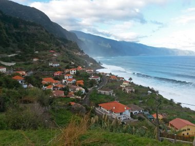 dalgalar deniz, cllifs, yeşil tepelerin yol ve Madeira Portekiz, köyde Kuzey Sahili, bulutlu mavi gökyüzü görüntüleme