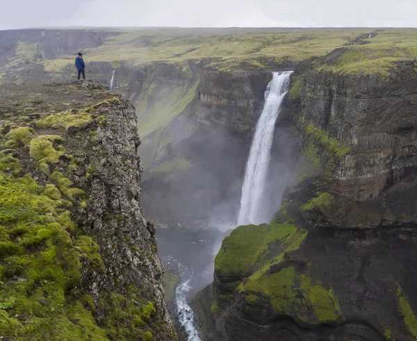 河窝谷与美丽的 Haifoss 瀑布在南冰岛与人在蓝色夹克站立在峭壁岩石和看风景 — 图库照片