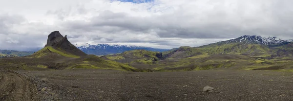 多彩的全景 饱览自然保护区火山岩景观的全景 Fjallabak 在冰岛中部与山 Einhyrningur 与绿色苔藓和蓝色积雪覆盖山脉 穆迪天空 — 图库照片