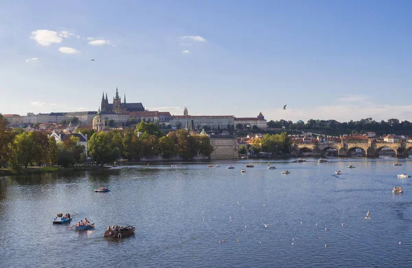 カレル橋ヴルタヴァ川と Gradchany プラハ城 聖ヴィート大聖堂のパノラマ チェコ共和国 黄金時間光 夏の晴れた日 観光客は ボートでリラックス — ストック写真