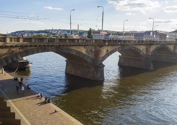 Repubblica Ceca, Praga, 8 settembre 2018: argine del fiume Moldava Praga con vista sul ponte della Legione, la maggior parte delle case legioni e Praga sul centro storico con rilassanti turisti e vela in piroscafo — Foto Stock