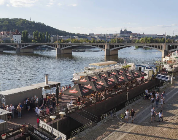 República Checa, Praga, 8 de setembro de 2018: Embarque no rio Vltava, Praga, com vista sobre a Ponte Legião, castelo da Legião e Praga e casas em Mala Strana, com relaxantes pessoas turísticas e casas flutuantes — Fotografia de Stock