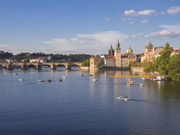 Panorama del ponte Carlo sul fiume Moldava e le case del centro storico, Praga, Repubblica Ceca, luce ora d'oro, giorno di sole estivo, turisti che si rilassano su pedalò — Foto Stock