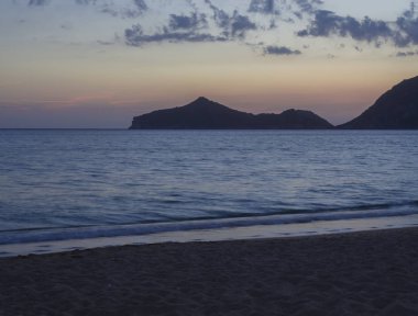 deniz sahilinde Agios Georgios Pagon beach Corfu Island, Yunanistan manzaralı porto timony defne, uzun pozlama üzerinde pembe turuncu güneş battıktan sonra mavi saatte.