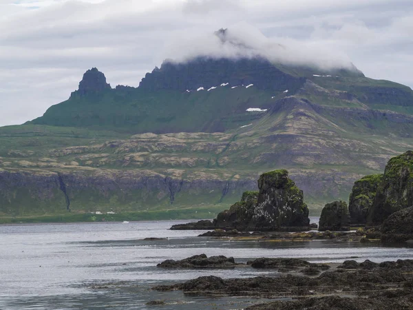 Gizemli görünümü güzel Kral ve Kraliçe Hornbjarg kayalıklardan Batı fjords uzak doğa rezerv Hornstrandir İzlanda ' ile büyük kuş cliff kayalar mavi deniz ve bulutlu gökyüzü ile en yüksek kaybetmiş siste.