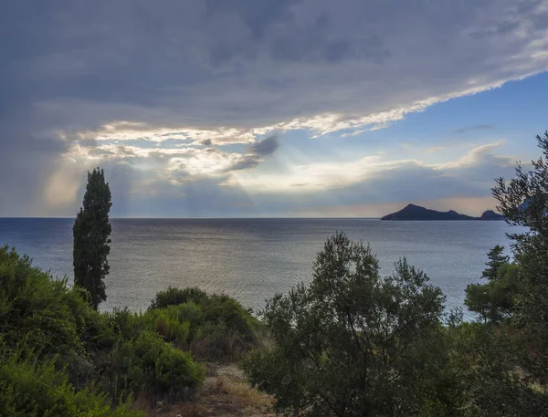 Καταπράσινο τροπική βλάστηση θάλασσας και του ουρανού με δραματική σύννεφα με ακτίνες του ήλιου ακτίνες και θέα στους λόφους timony κόλπο Πόρτο, Κέρκυρα, Ελλάδα — Φωτογραφία Αρχείου