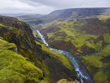 Manzara mavi nehir Fossa Vadisi su akışı ve yeşil tepeler ve yosun kaplı uçurumlar, South Iceland, yaz moody gökyüzü