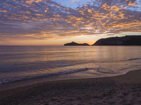 güzel mavi pembe turuncu bulutlar ve Corfu Island, Yunanistan porto timony Körfez Manzaralı Agios Georgios Pagon sahilde günbatımı