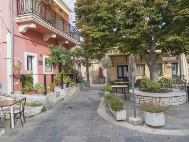 Yunanistan, corfu, Doukades, 28 Eylül 2018: büyük ıhlamur ağacı ve meyhane ve taş geleneksel evleri ve kaldırım köyü Doukades Korfu Adası Yunanistan, eski kare