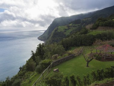 Dik kayalıklarla, deniz, oyuk ve çiçek bahçesi Miradouro da Ponta açısından ile nefes kesen manzarası yapmak Sossego Nordeste Sao Miguel Island, Azores, Portekiz