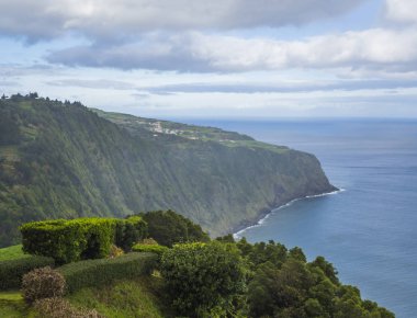dik kayalıklarla, deniz, hedge bush ve çiçek bahçe bakış açısıyla Miradouro da Ponta do Sossego Nordeste, Sao Miguel adada Azores, Portekiz görüntülemek