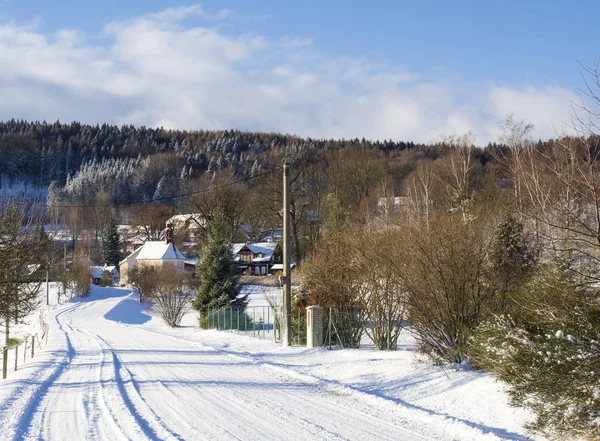 Vue d'hiver sur village travnik avec chapelle, chalet à colombages et arbres, paysage rural enneigé avec dans la montagne luzicke hory — Photo