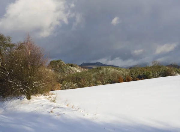 Neve coberto prado com árvores decíduas e coníferas floresta e colinas com torre de vigia, céu azul. Paisagem de inverno em luzicke hory montanha, República Checa — Fotografia de Stock