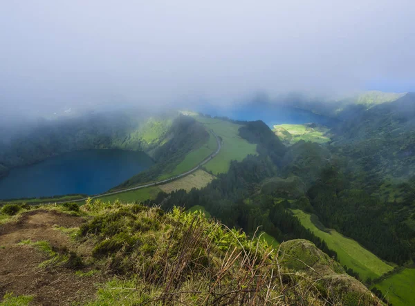 Prachtig uitzicht over de vulkanische meren. Groene Lagoa de Santiago en blauwe Lagoa Azul met Sete Cidades dorp, gedeeltelijk bedekt door mist, mist en wolken. Sao Miguel op de Azoren, Portugal — Stockfoto