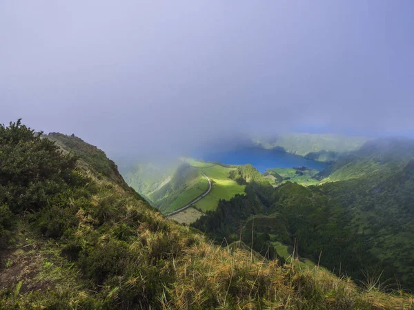 Приголомшливий вид на вулканічні озера. Лагоа де-Сантьяго зелений і синій Лагоа Azul з Sete Cidades село, частково покривається туману і хмари. Сан-Мігель Азорські острови, Португалія — стокове фото