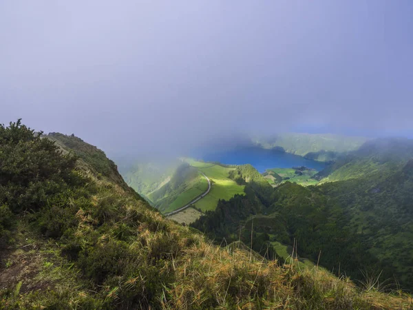 Prachtig uitzicht over de vulkanische meren. Groene Lagoa de Santiago en blauwe Lagoa Azul met Sete Cidades dorp, gedeeltelijk bedekt door mist, mist en wolken. Sao Miguel op de Azoren, Portugal — Stockfoto