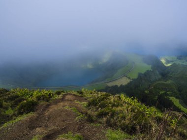 Çarpıcı görünümü volkanik göller üzerinde. Yeşil Lagoa de Santiago ve mavi Lagoa Azul'la Sete Cidades Köyü, kısmen sis sis ve bulutlar tarafından kapsanan. Sao Miguel Azores, Portekiz