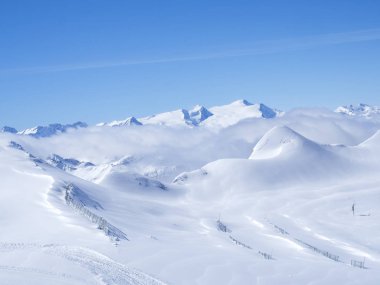 Manzara karla kaplı yamaçları ve mavi gökyüzü ile kış, Kitzsteinhorn Dağı'nın tepesinden görüntüleyin. Kaprun Kayak Merkezi, Milli Parkı Hohe Tauern, Avusturya Alplerinde, Europe.