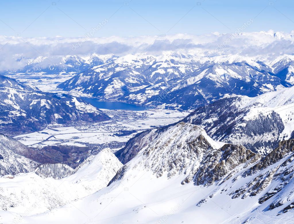 Winter landscape with snow covered slopes and blue sky, with Aerial view of Zell am See lake from the top of Kitzsteinhorn mountain on . Kaprun ski resort, National Park Hohe Tauern, Austrian Alps