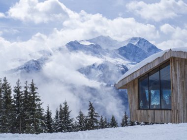 Zell Am See, Avusturya, 14 Mart 2019: modern ahşap yazlık Restoran Smittenhohe Dağı'nda Kaprun Kayak Merkezi üst görünüm. Mavi gökyüzü bulutlar, güneşli kış günü ağaç ve dağın zirvesinde
