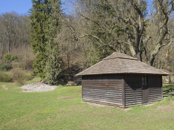 Altes historisches Blockhaus im Frühlingswald, Gras und Bäume in der Landschaft der mittelböhmischen Region an einem sonnigen Tag, blauer Himmel — Stockfoto