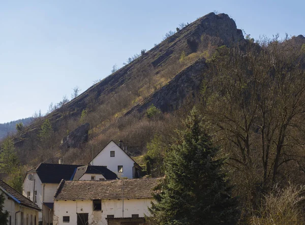 Vista sul villaggio con scogliera rocciosa Svaty Jan pod Skalou, Beroun, Boemia centrale, Repubblica Ceca, Famoso luogo di pellegrinaggio, giorno di sole primaverile, cielo blu — Foto Stock