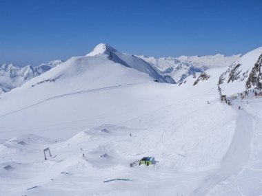 Kayak merkezi Stubai Gletscher, Stubaital, Tyrol, Avusturya Alpleri 'nde kar kaplı dağ yamaçları ve kayakçılarla dolu kış manzarası.
