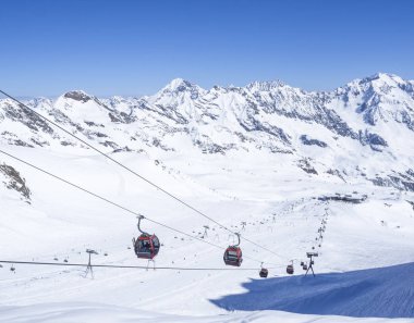 Stubai Glacier, Avusturya, 2 Mayıs 2019: Stubai Gletscher kayak merkezinde Schaufelspitze dağının tepesine çıkan ücretsiz sürüşler ve pistler ve kırmızı Teleferik arabalar ve sandalye asansörleri ile karla kaplı yamaçlar