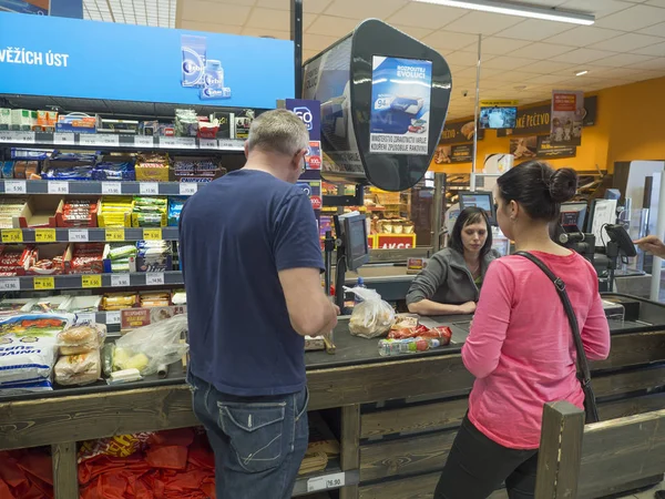 Çek Cumhuriyeti, Cvikov, Nisan 25, 2019: genç kadın ve erkek alışveriş ve Penny pazar indirim süpermarkette nakit masada ödeme, depolanan mallar.
