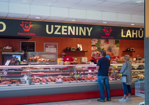 Cvikov, Çek Cumhuriyeti - 24 Mayıs 2019: Kasaplıkta alışveriş müşterilerine et gösteren kadın kasap ile peni pazarında kasap dükkanının ön görünümü
