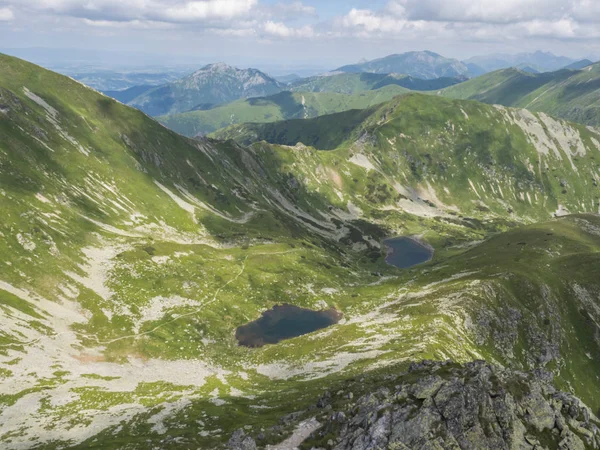 Beautiful vivid blue mountain lakes Horne and Dolne Jamnicke pleso with green mountain peaks view from the Jamnice sedlo saddle, Western Tatras mountains, Rohace Slovakia, summer sunny day blue sky