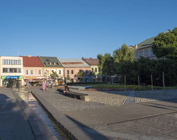 LIPTOVSKY MIKULAS, LIPTOV, SLOVAKIA, July 4, 2019: View to the main square with park and buildings in the city center of Liptovsky Mikulas town with walking people. Summer sunny day, golden hour — Stock Photo, Image