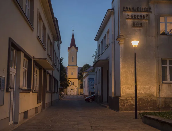 LIPTOVSKY MIKULAS, LIPTOV, SLOVAKIA, 4 de julho de 2019: Vista para a praça principal com parque e edifícios no centro da cidade de Liptovsky Mikulas cidade com luzes de rua e igreja de Evanjelicky kostol. Verão — Fotografia de Stock